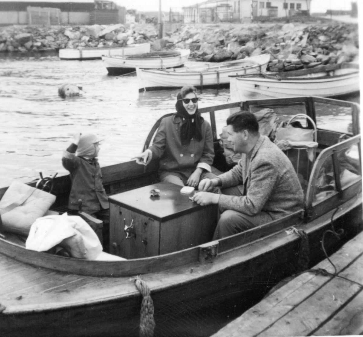 Kogg ved brygga i Kragerø. Blindtarmen. Familie planlegger tur. Linjegods (vinmonopolet) i bakgrunnen. 1950-tallet.