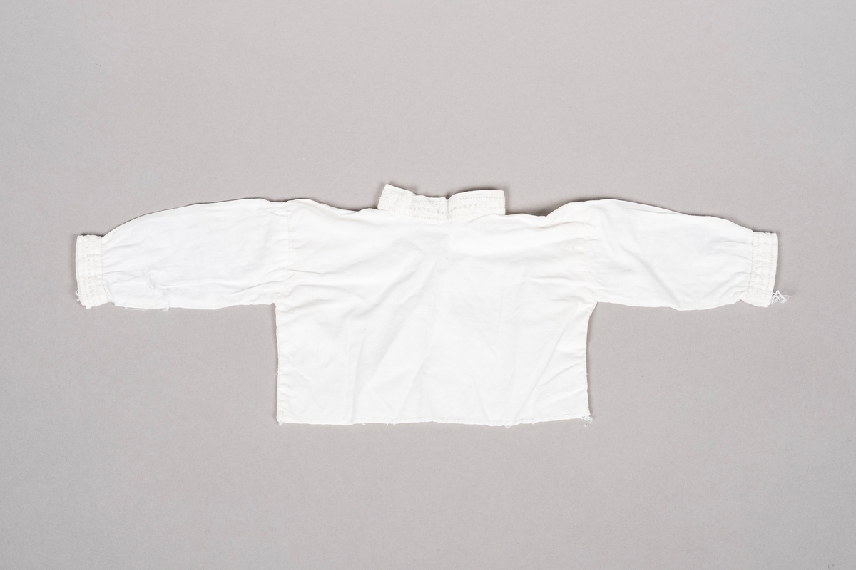 Hvit "bunadsskjorte" i bomull med kinakrage og hullbroderi langs kantene.
