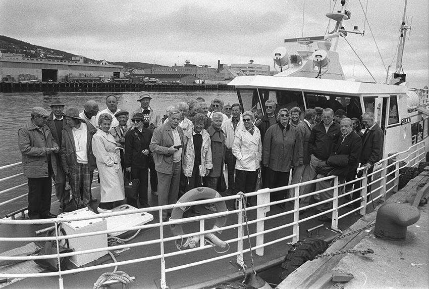 Mennesker ombord i en båt ved dampskipskaia i Harstad.