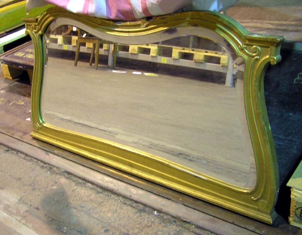 Spegel i nyrokokoinspirerad stil av trä, förgylld. En snidad ram med dekorativa ornament omger spegelglaset. Baksida av ofärgat trä. Spegeln tillhör spegelbord 2465:1 samt spegel 2467:1.
