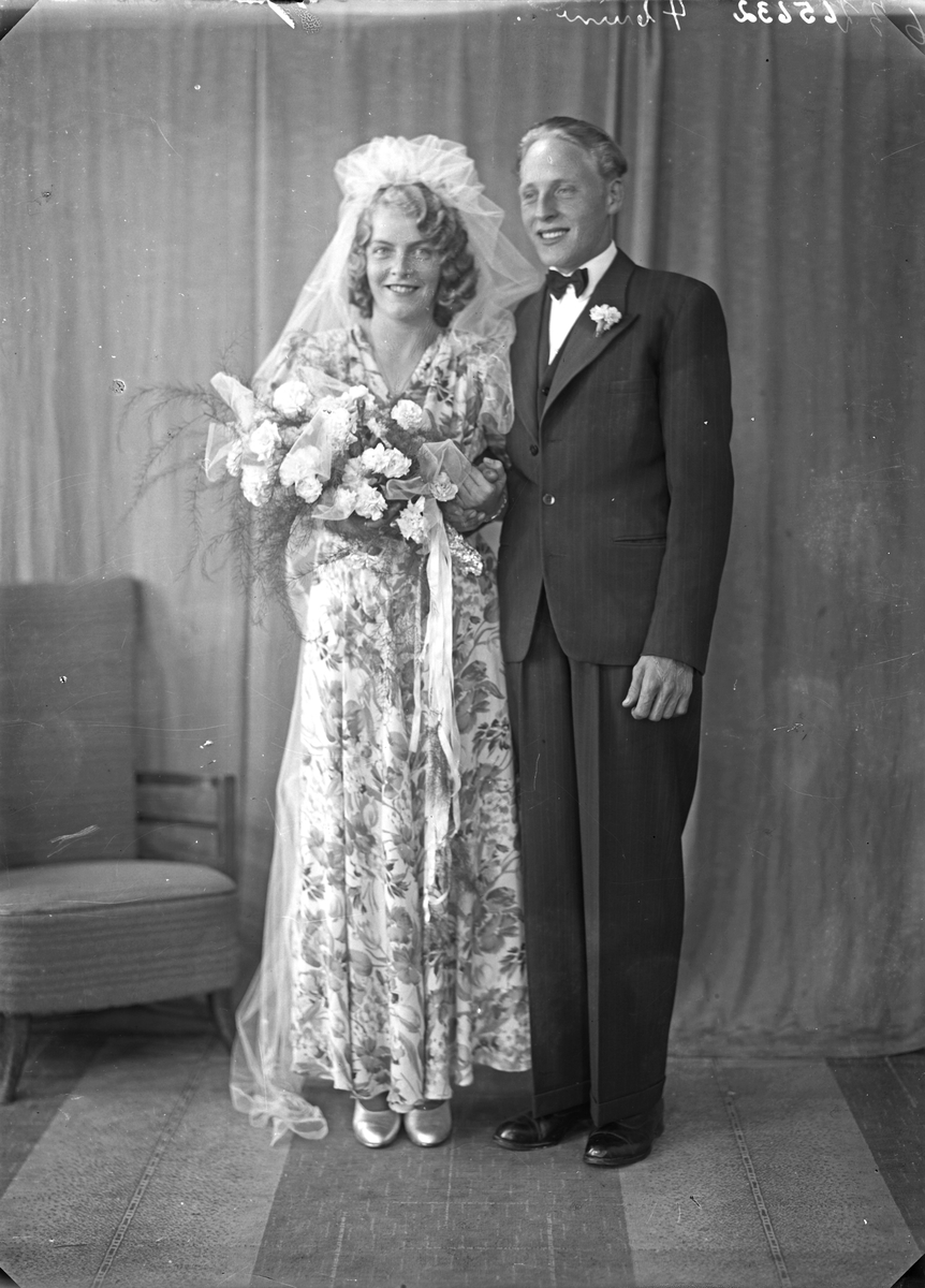 Brudebilde. Ung kvinne i blomstret brudekjole og ung mann. Brudepar. Bestilt av Hr. Arthur Nyland. Sørhaug