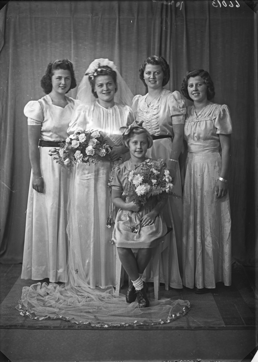 Brudebilde. Familiegruppe på fem. Fire unge kvinner, den ene brud, og en ung pike. Søstre. Brudgruppe. Bestilt av Herr Lauritz Hovland