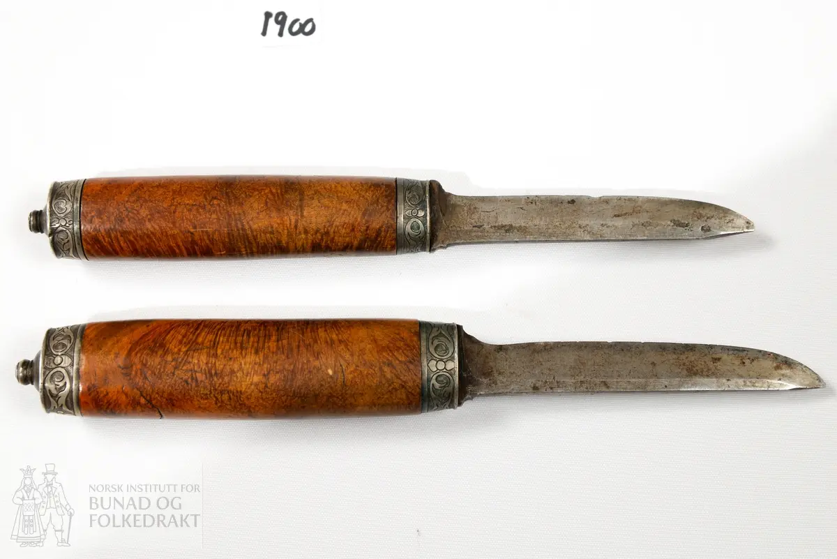 Kniv, tvislir. Samansett av to lerslirer, initialene HSS.  Årstalet 1735. Dekor på båe slirene. 
Treskaft av bjørk, godt brukte blad av jern. 
Sylvholkar. Kvivane og slira er av ulik alder, og knivane ser ut til å ha kome til etter kvart. Kanskje 100 år yngre. Det eine knivskaftet er litt grøvre enn det andre.
Knivslirene er sett samman av ein gaffel - liknande stav. Slirene er laga med firkanta smettestolar som "gaffelen" blir stukke ned gjennom, og som låser slirene saman. Gaffelen er av jern, og påsett toppfeste i messing til oppfesting i belte. Denne svingar laust rundt i jern - gaffelen. Leret har skore dekor.
Sylvholkene på båe knivane har gravert dekor.