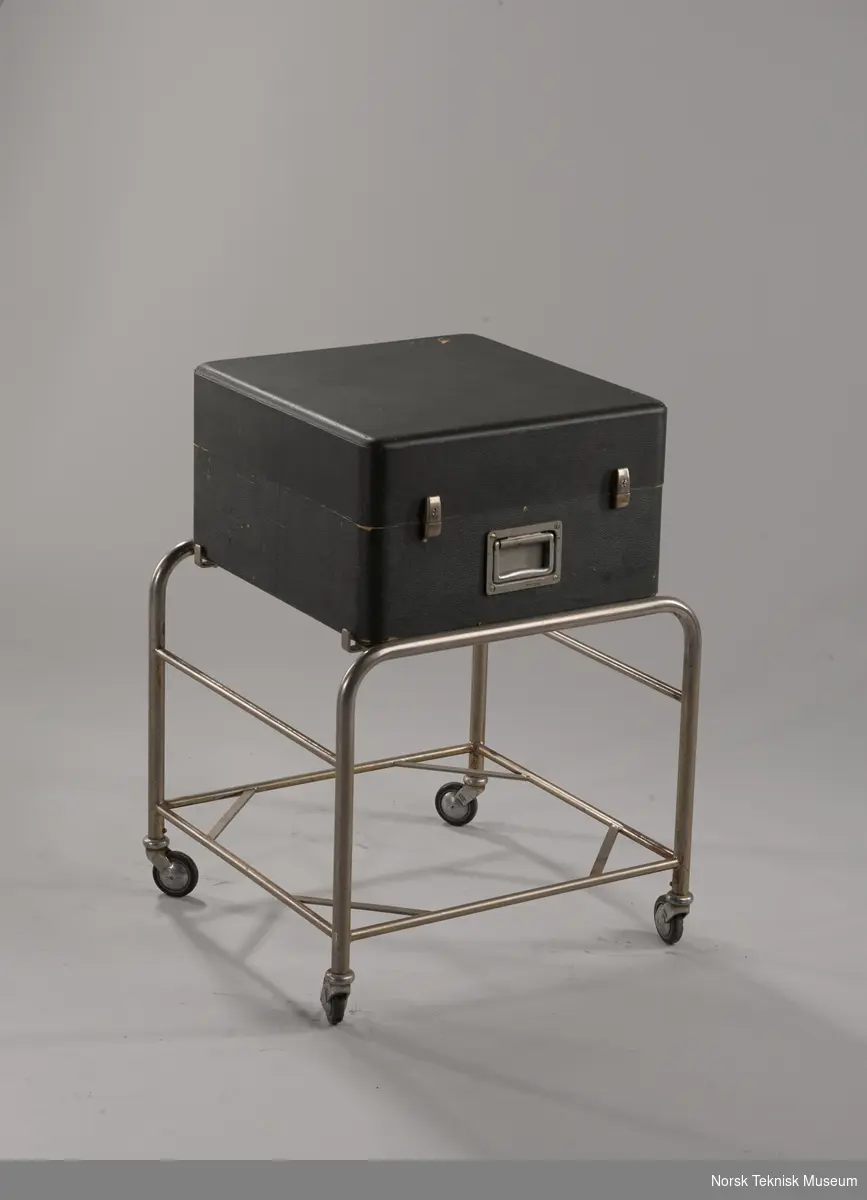 Med pilottone. Med radiorør. I original koffert på NRK-laget stativ med hjul.