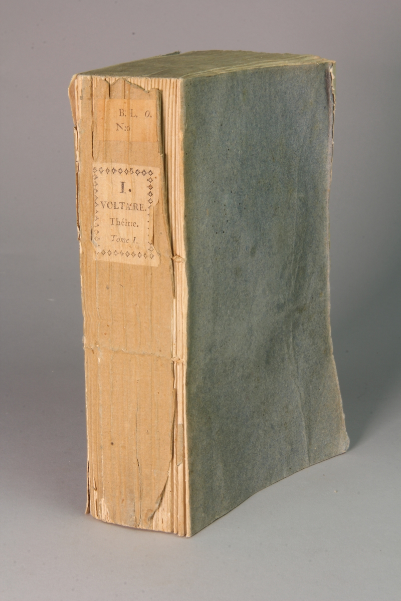 Bok, häftad,"Oeuvres complètes de Voltaire." del 6, tryckt 1785.
Pärm av gråblått papper, skurna snitt. Blekt rygg med pappersetikett med tryckt text med volymens namn och nummer.