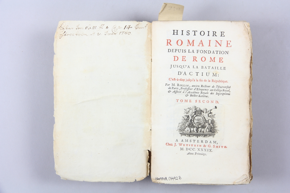 Bok, pappband, "Histoire Romaine", del 2, tryckt 1739 i Amsterdam. Marmorerade pärmar, blekt rygg med påklistrade etiketter, delvis oläsliga. Oskuret snitt. Anteckning om inköp på pärmens insida.