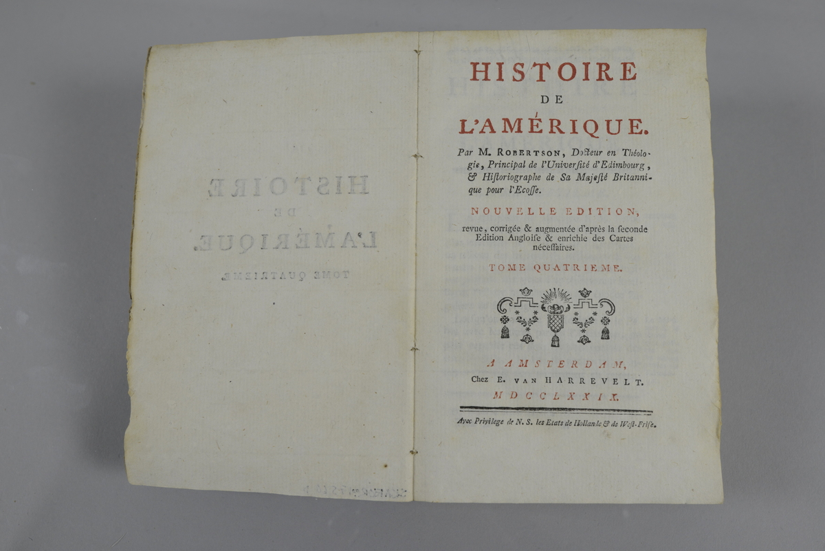 Bok, pappband, "Histoire de l´Amerique", del 4, skriven av Robertson, utgiven 1779 i Amsterdam.
Pärmen klädd med grått papper. Med oskurna snitt. På ryggen tryckt etikett med nummer samt oläslig påskrift. Med karta samt plansch.