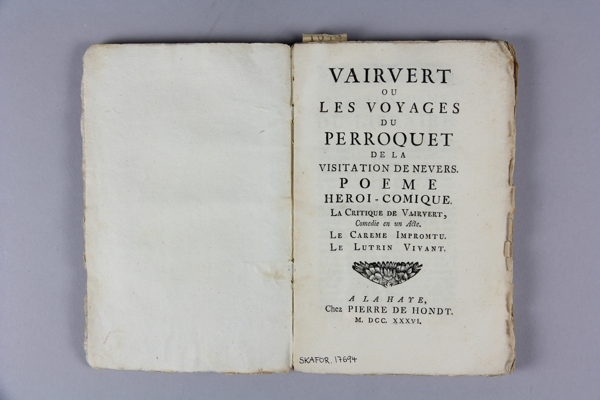 Bok, häftad, "Vairvert ou les voyages du perroquet", tryckt i Haag 1736.
Pärm av marmorerat papper, oskurna snitt. Blekt rygg med etikett med samlingsnummer.