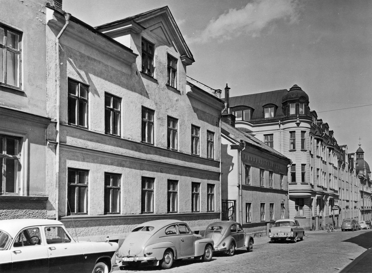 Parti av Vattengatan i Norrköping 1958. Byggnaden vid korsningen av Vattengatan och Luntgatan i kvarteret Pokalen var ett empirehus i två våningar från 1800-talets mitt.  Fotografiet är taget i samband med rivningsansökan 1958. Vy mot nordost.
