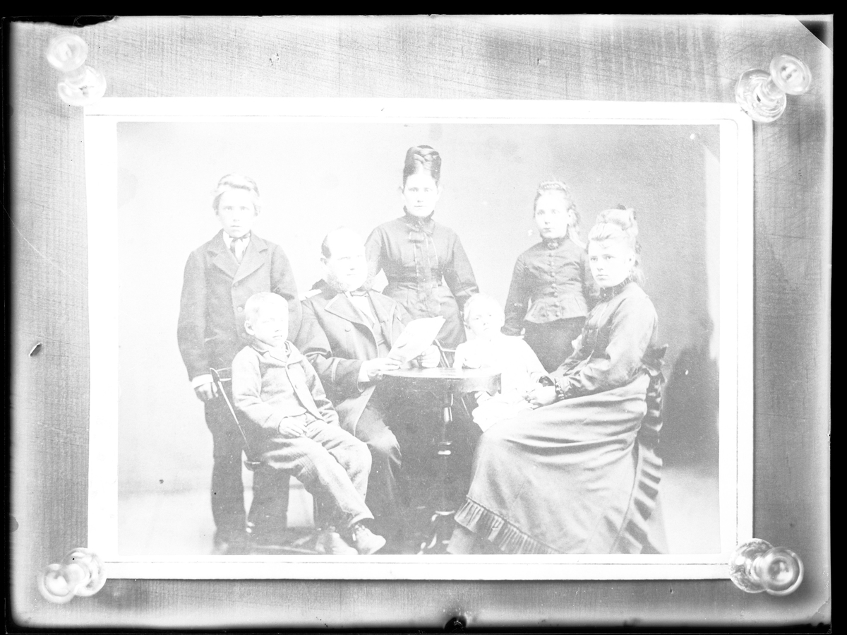 Reprofotografi beställt av "Hr. Petersén", troligen Petrus Vilhelm Petterssén. Bilden är en gruppbild på sju personer, troligen en familj.
