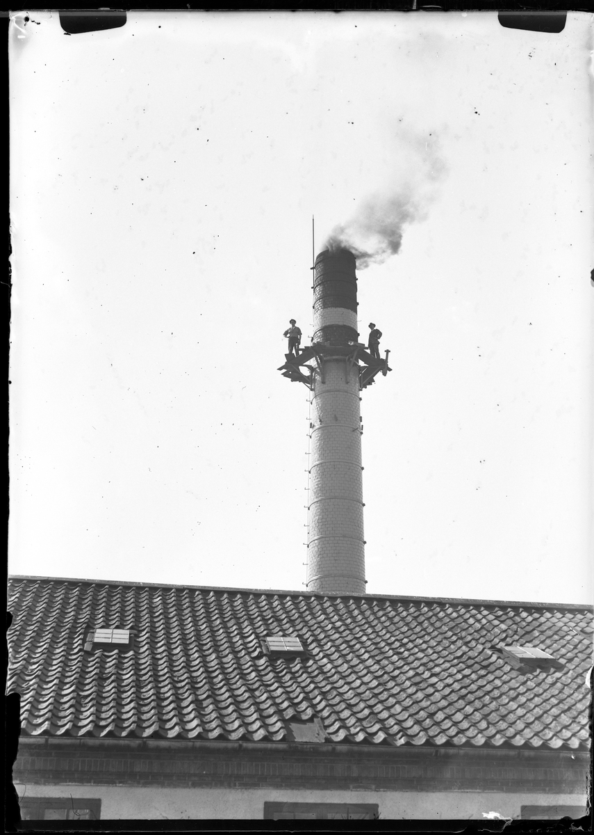 Arbetare på Alingsås bomullsväveris fabriks skorsten.