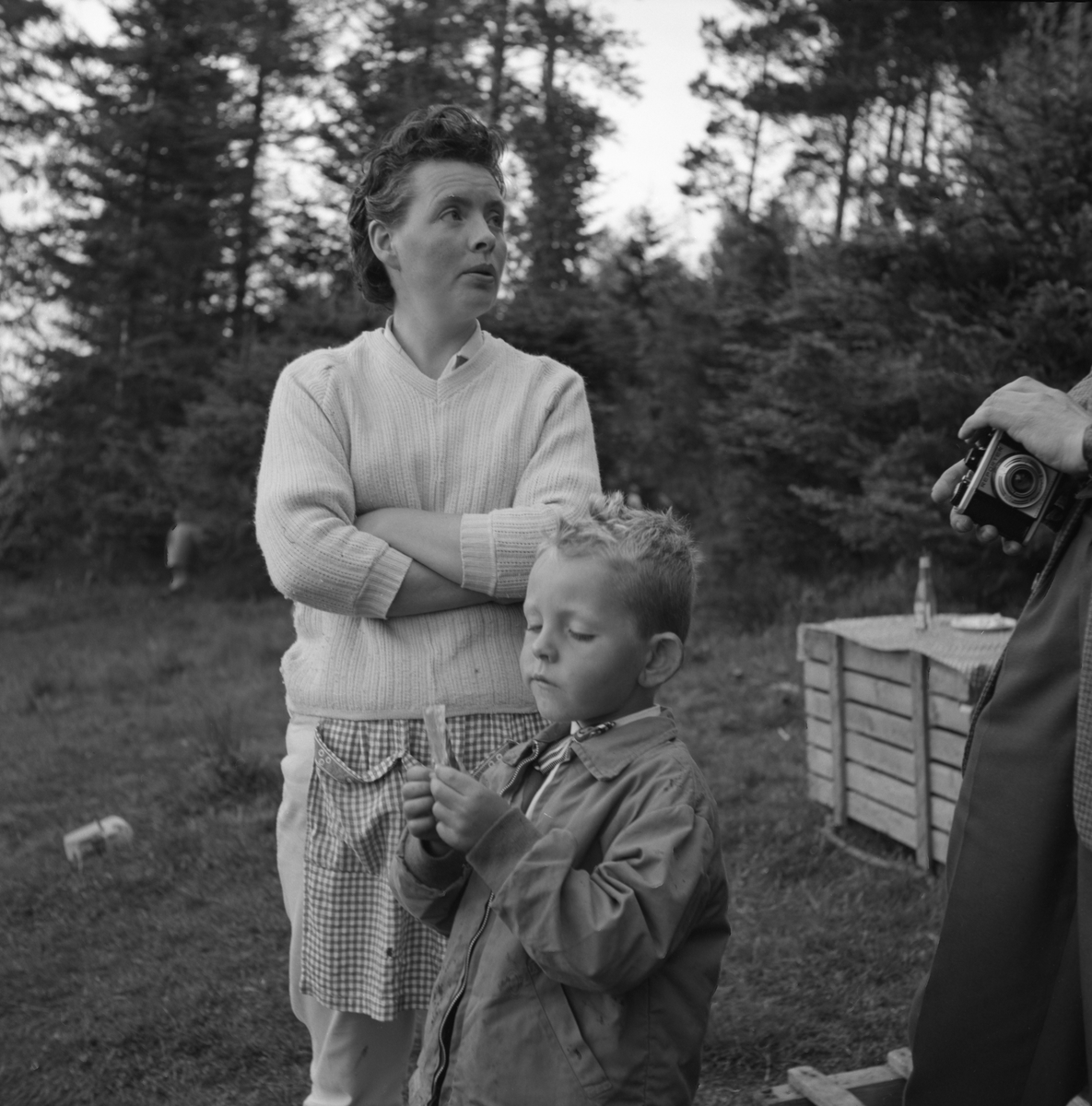 Portrettfotografi av en gutt og ei kvinne som står ved en mann med et fotokamera(Reporter). Karsten Aa. N feirer sin bursdag.