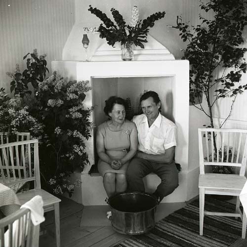 Hilding sitter med sin fru i en öppen spis med en gryta framför fötterna, Sunnanåker 1968.