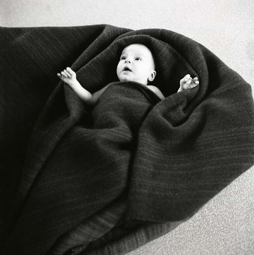 Ett barn ligger inlindat i en filt, 1969.