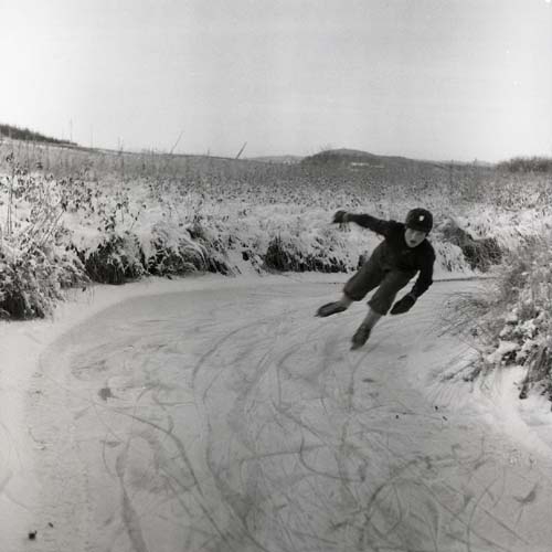 Ett barn åker skridskor i en frusen isränna, 1954.