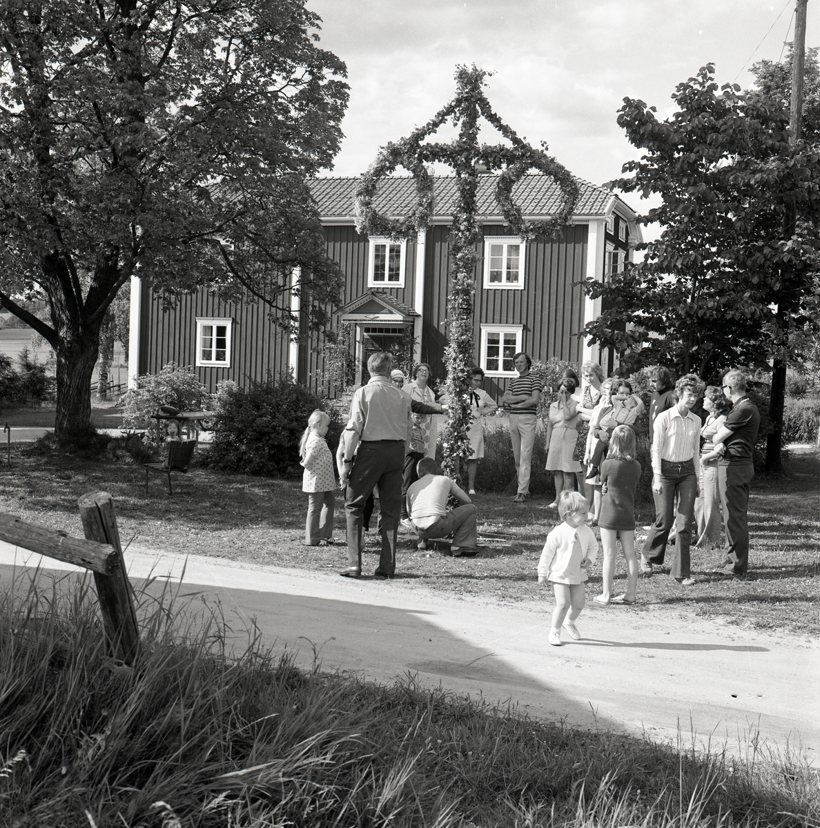 På gården Sunnanåker dansar midsommarfirare runt stången, 1972.