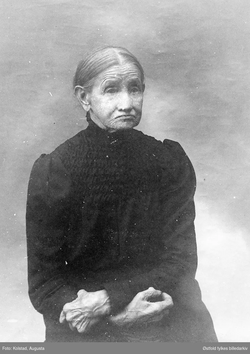 Portrett av Helene Kolstad (1828-1926), mor til fotografen, gårdbrukerkone på gården søndre Kolstad i Askim. På bildet er hun enke. Bodde sine siste år på Olavsrud, Korsegård sammen med sine døtre, Se ØFB.AKO.00004.