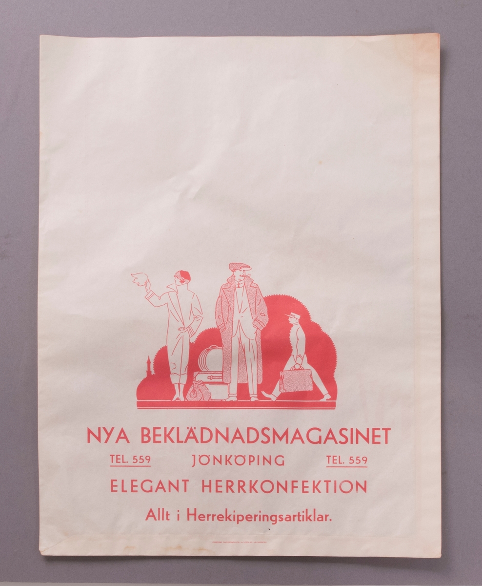 Påse av vitt papper med tryckta illustrationer och texter på båda sidor i röd färg. Bilden på en av sidorna föreställer en kvinna och en man, klädda i ytterkläder (1920-talsmode), och med bagage placerat vid fötterna. Bakom dem går en uniformsklädd man bärande en resväska.