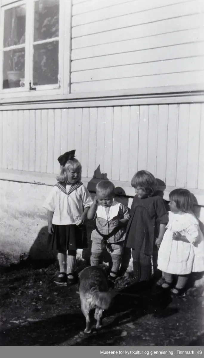 Nordvågen. Fire barn og en hund utenfor Johannes Klevstads bakeri. Ca. 1930.
