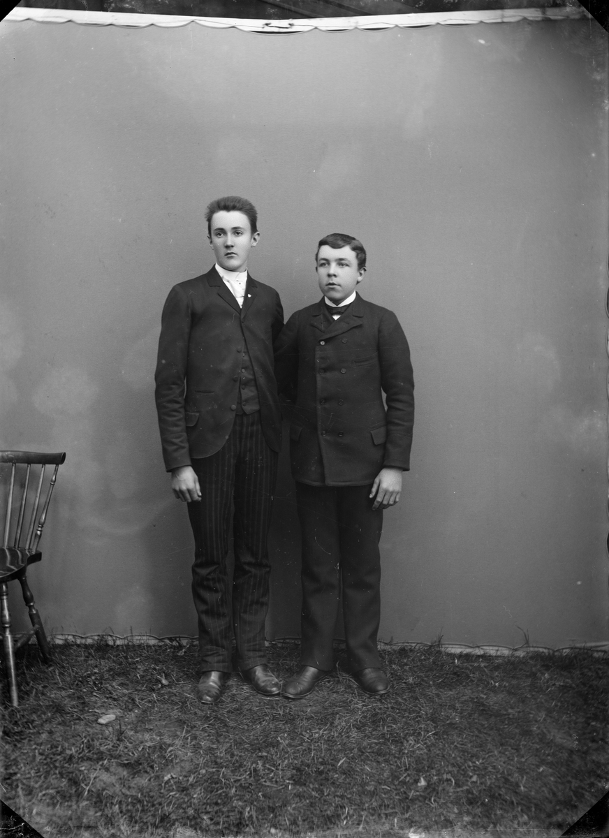 2 yngre menn i mørke dresser, atelierfoto