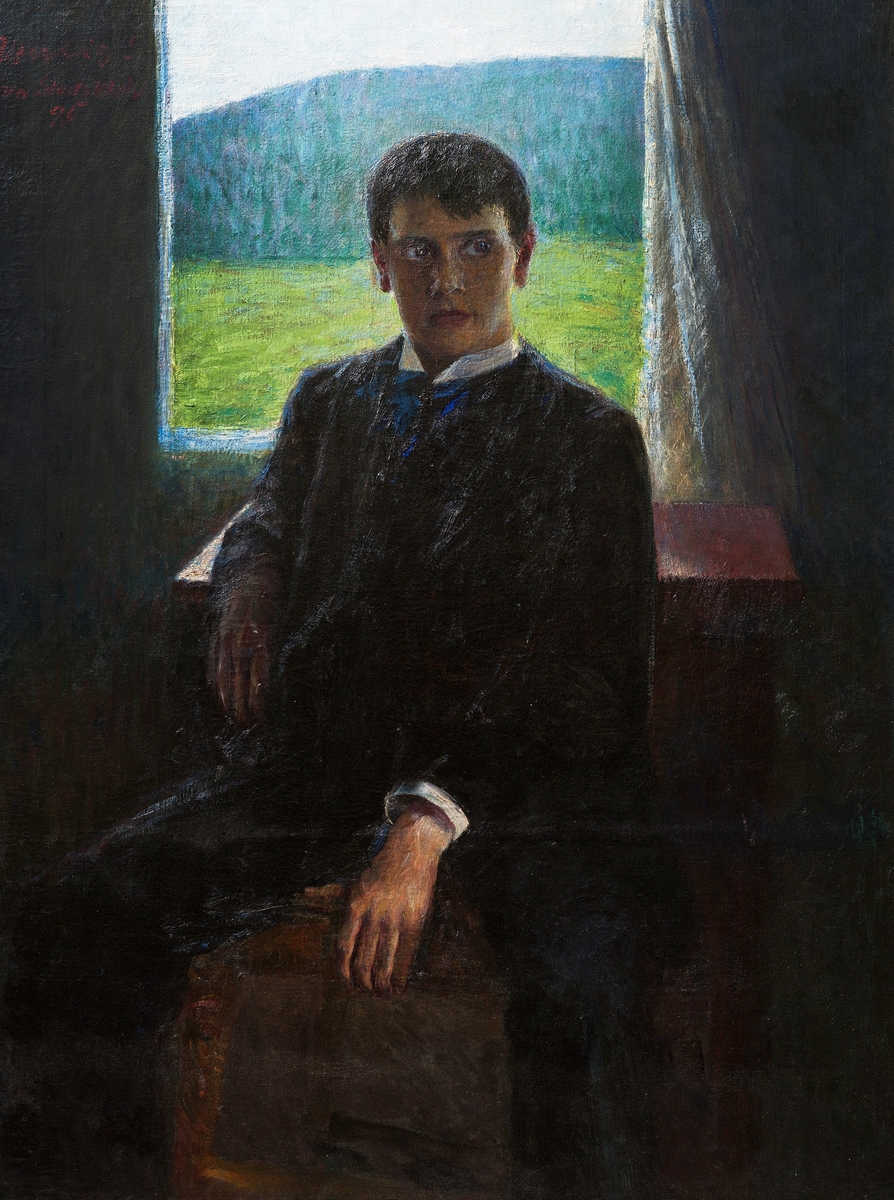 Portrett av ung mann sittende foran vindu