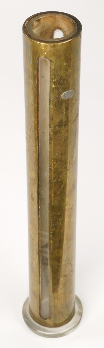 Reagensrør av glass belagt med en kobberlegering. Legeringen har to vertikale vinduer med inngraverte måleskalaer fra 0,1 til 1 l