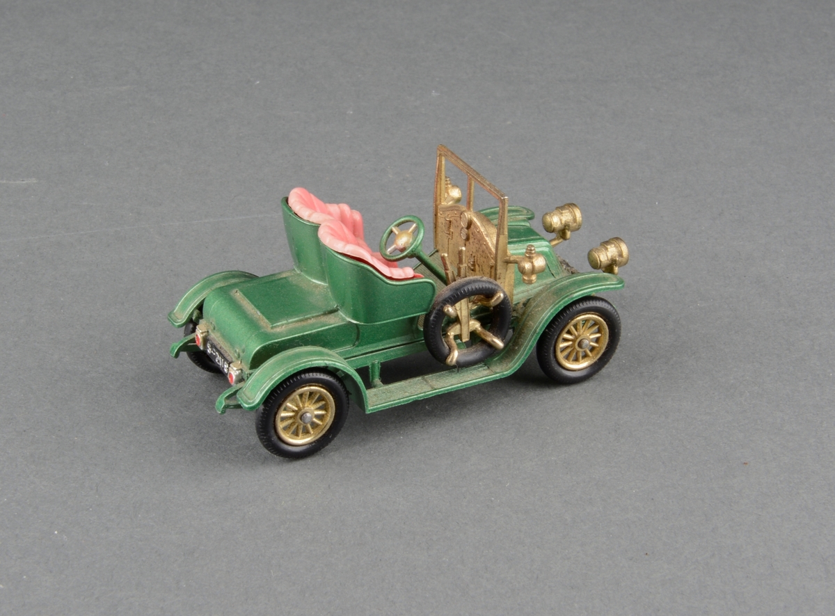 Modell av vetarnbil 1911 Renault. Kabriolet med to seter. Lave hjul og reservehjul på siden. Ratt på høyre side. I originaleske.