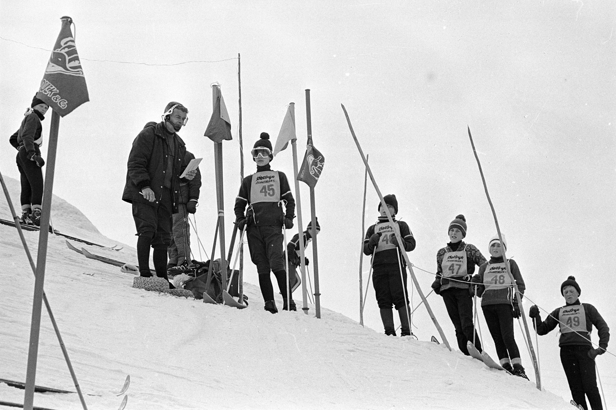 Flere gutter med ski står klart til start, "Aprilspøken" slalåmrenn i Tryvannskleiva. Fotografert 23. mars 1969.