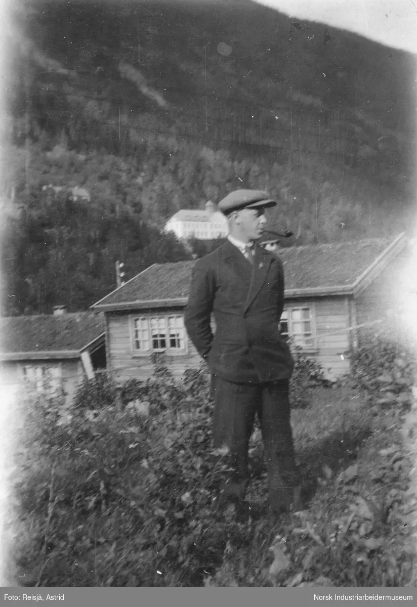 Mann foran bygg på Granli. Rjukan sykehus i bakgrunnen.