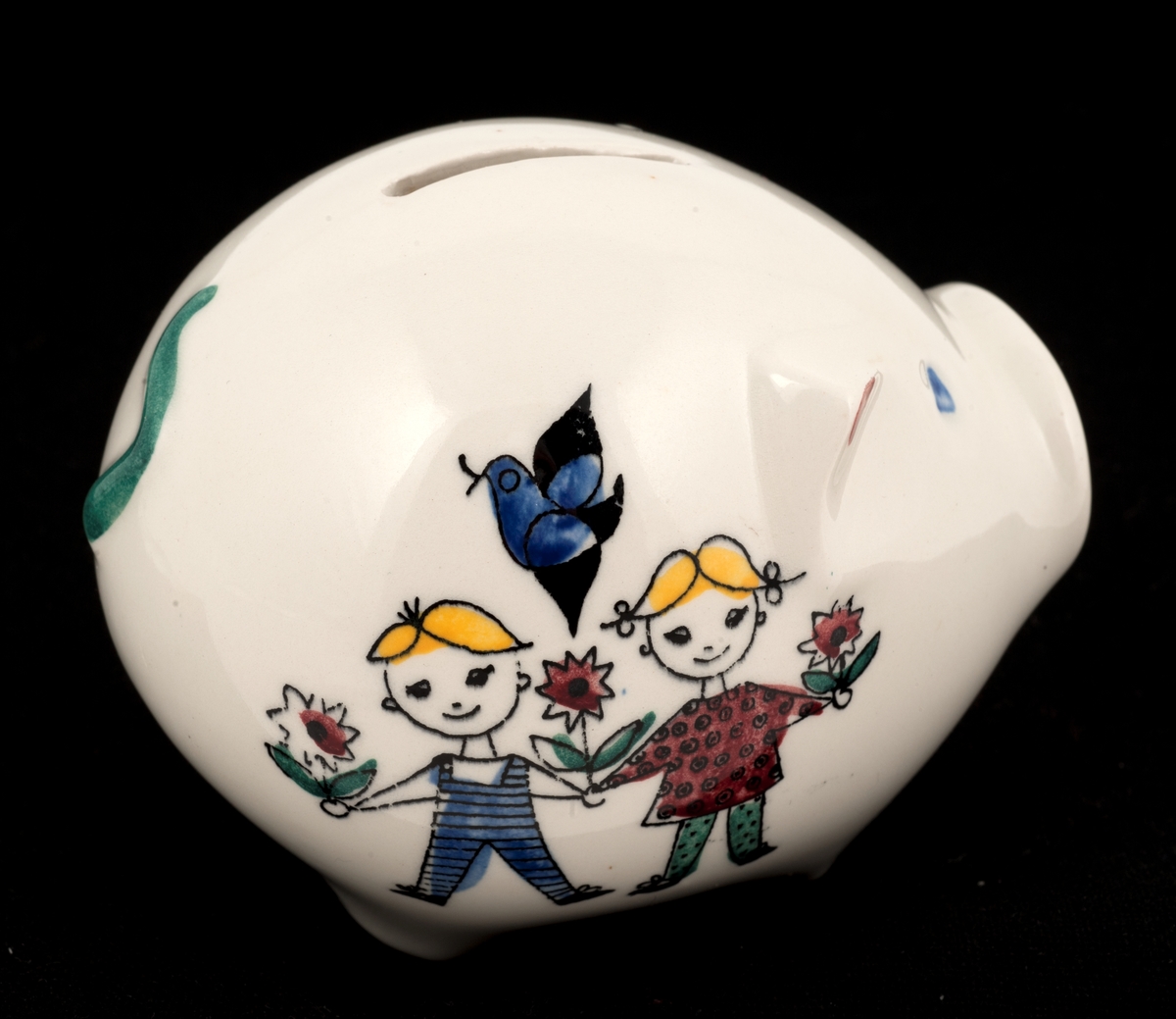 Sparebøsse av keramikk (flint). Formet som sparegris med  blomst, barn og katt som dekor.