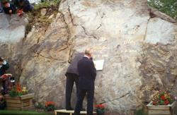 Hans Majestet Kong Harald setter sitt navn på stenen.