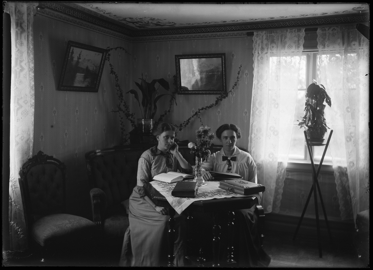 Två kvinnor läser vid bord