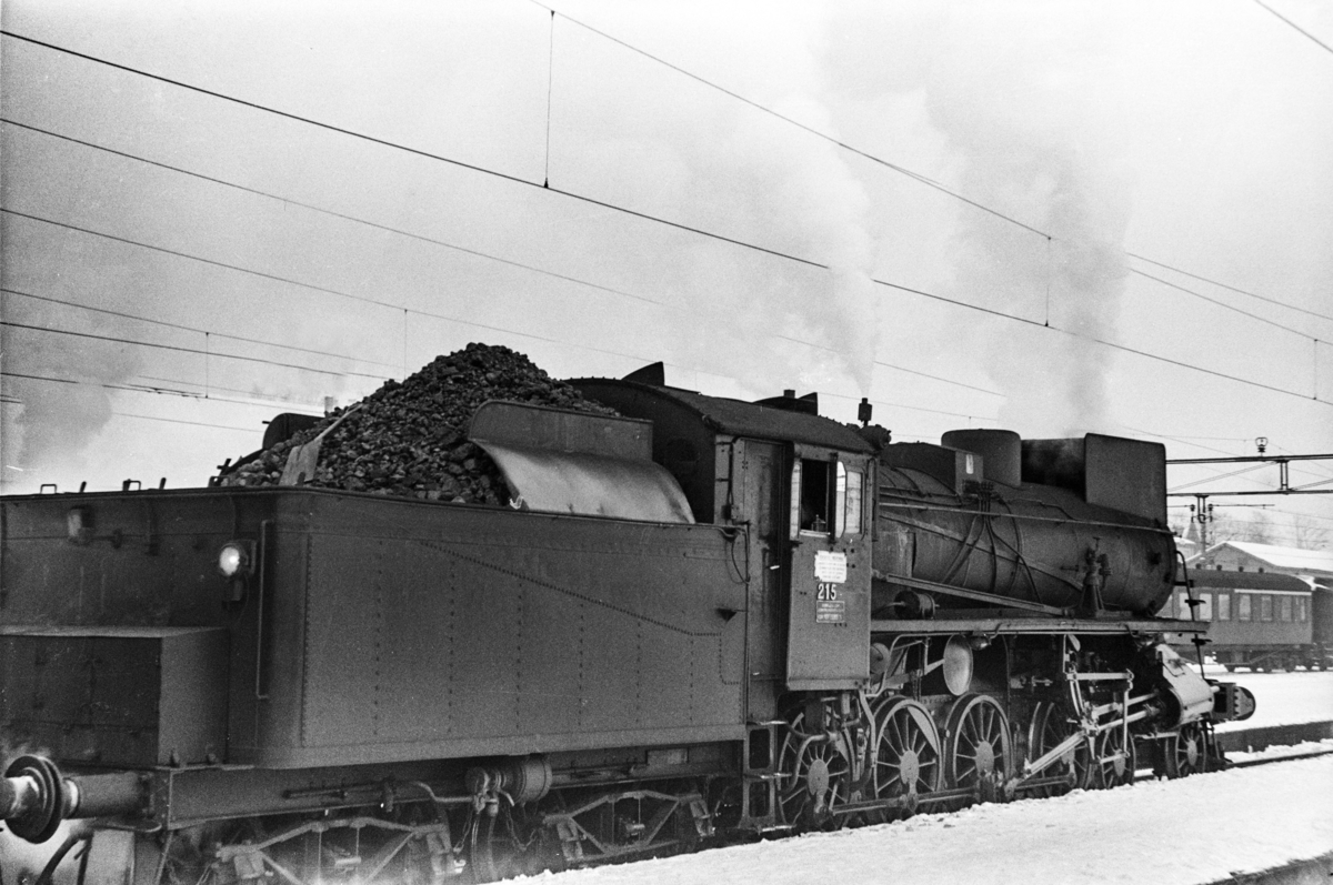 Damplokomotiv type 26a nr. 215 med dagtoget fra Oslo Ø til Trondheim over Røros, tog 301, på Hamar stasjon.