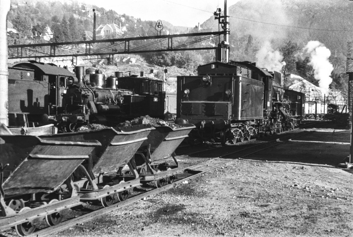 Ved kullingsanlegget på Bergen stasjon, tippvogner med kull i forgrunnen. I bakgrunnen damplokomotiv type 31a nr. 320.
