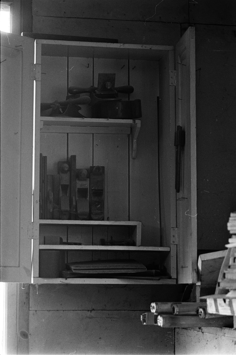 Skåp med hyvlar på väggen ovanför hyvelbänk i verkstadens äldre del, Enköpings Kvarnstensfabrik, Bangårdsgatan 13, Enköping, Uppland 1984