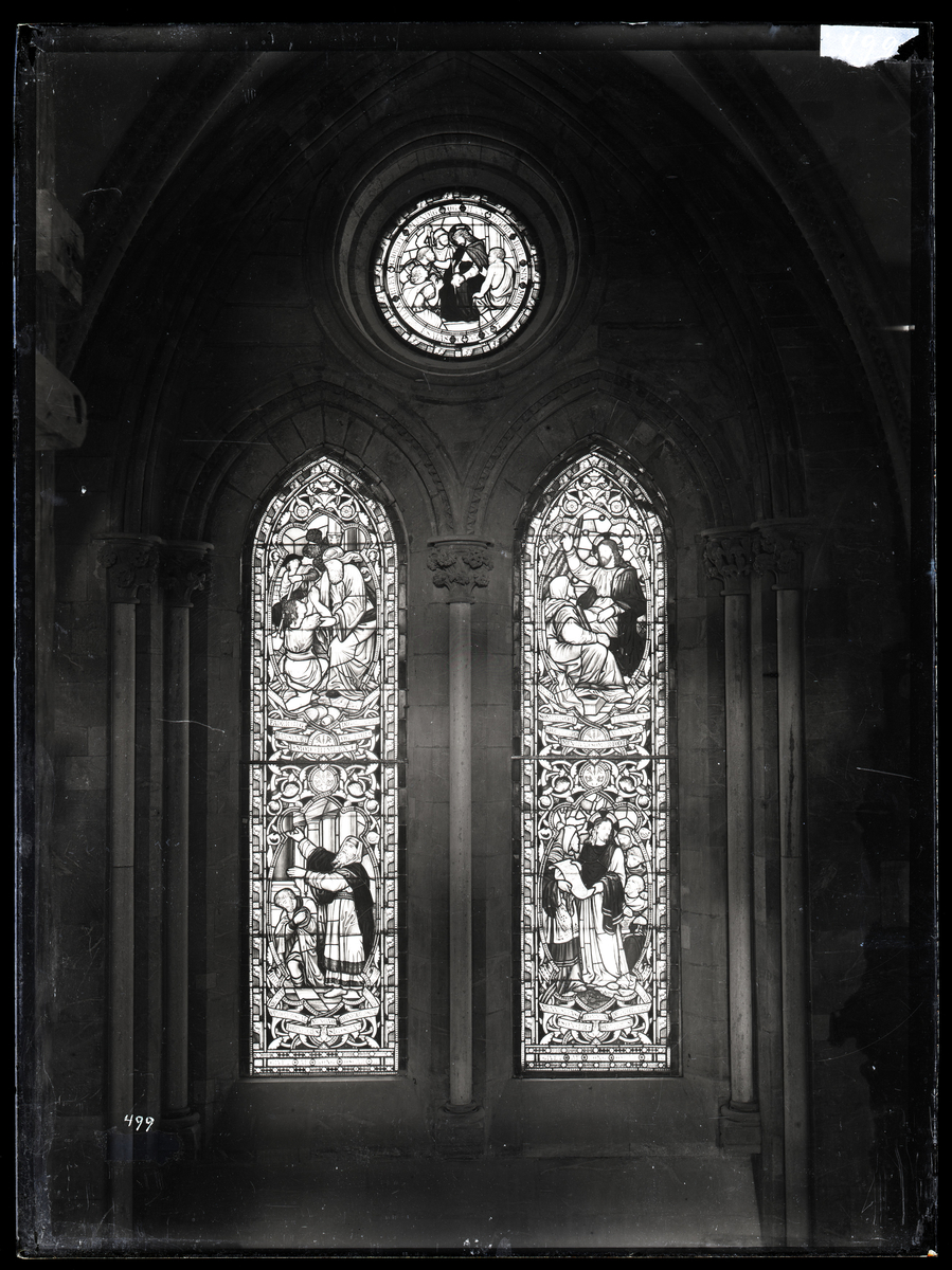 Vindusgruppe fra sideskipet i koret i Nidarosdomen. Glassmaleriene var en del av Kong Oscars gave og ble laget i London i 1886. De er senere skiftet ut.