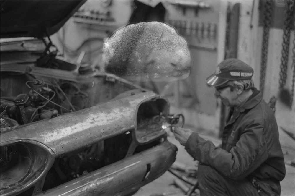 Lind & Greva i Mosjøen, Mars 1975. Markering i forbindelse med 20 år som Ford forhandler.
Bilmekaniker i arbeid med bil. Leif Lukkasen?