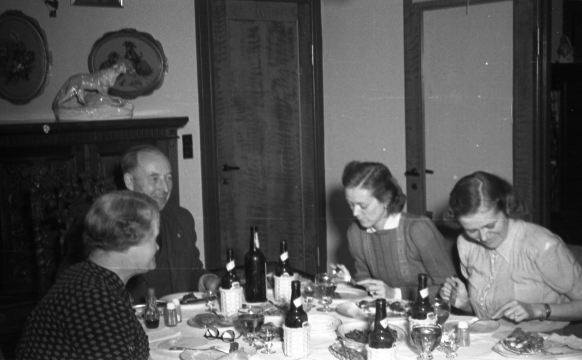 Middag. En mann og tre kvinner samlet rundt middagsbordet. Suderøy på vei til fangstfeltet.