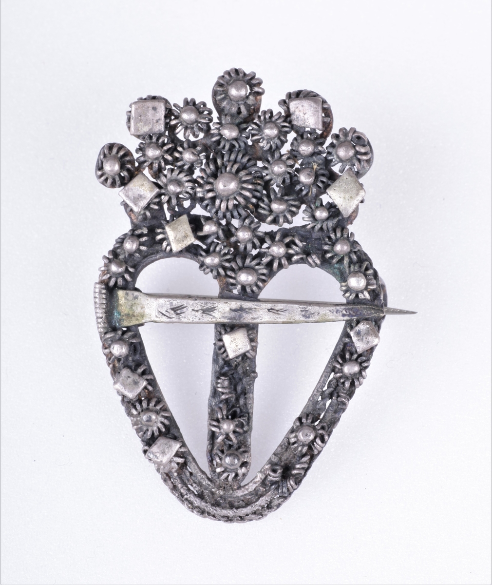 Sølja er hjerteformet med en krone av filligran.