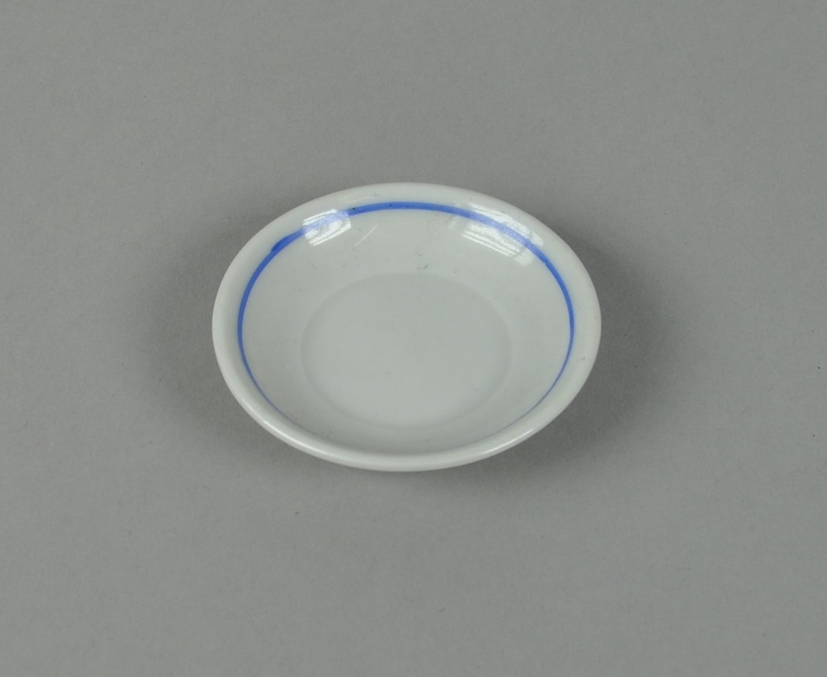 Skål av glassert keramikk, med påmalt blå sirkel i midten.