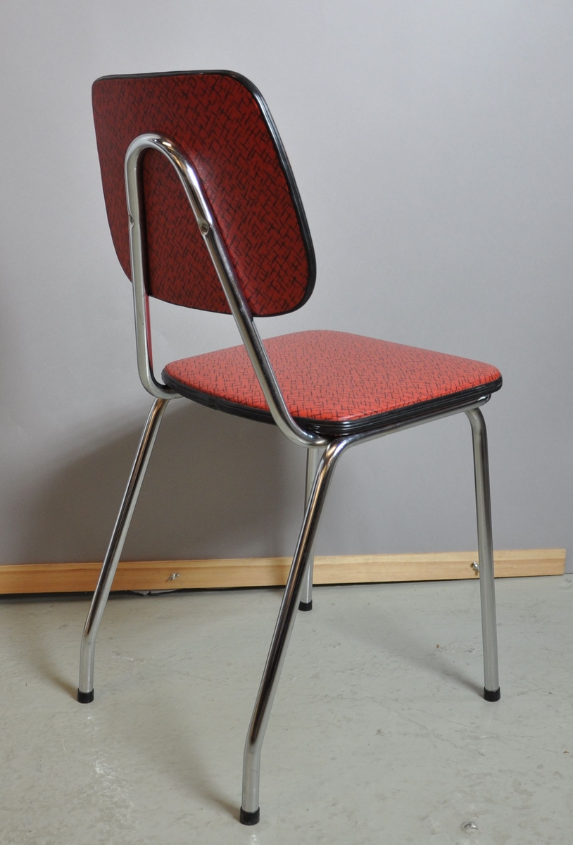 Kjøkkenstol med rødt trekk. Ryggstole og bein er av metall. Sete og rygg er trekt med gummi/skai.