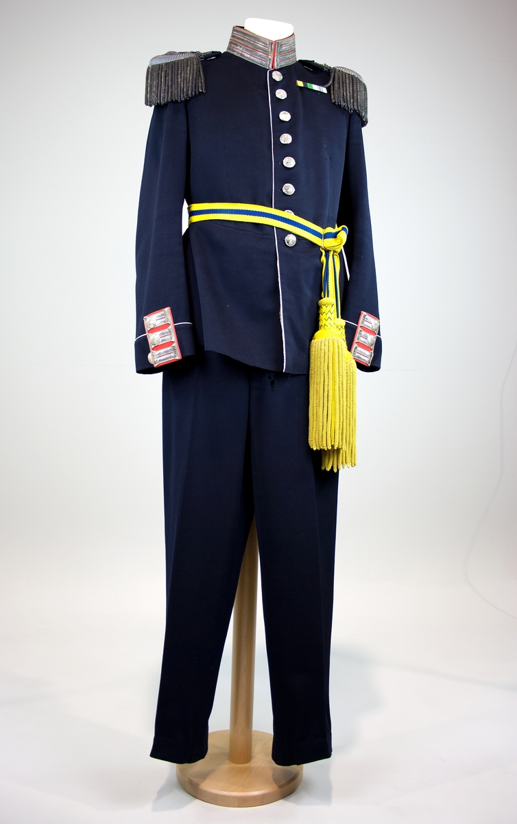 Uniformsbyxa av blått ylle. Vit paspoal i sidorna. Knappar av blå plast i midja och gylf samt benslut.