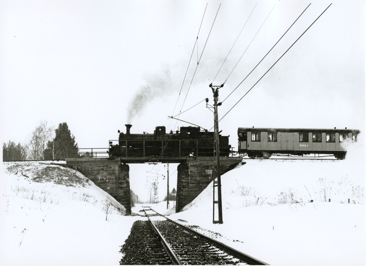 Dala - Ockelbo - Norrsundet Järnväg, DONJ lok 8.

Ånglok med personvagn på järnvägsbro över korsningen av bandel 176 och 104 under vintertid.