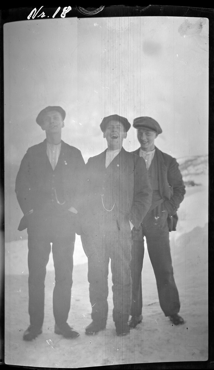 Gruppeportrett av tre lystige menn.