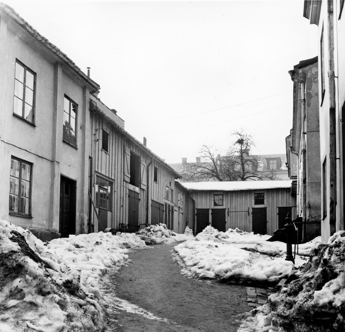 Innergård tillhörande kvarteret Haken 9 i Norrköping. Bilden är tagen i samband med rivningsansökan 1953. John Journath Byggnadsbyrå kommer under 1950-talet bygga nya bostäder inom kvarteret med början på tomten Haken nr 9. Vy mot sydväst.