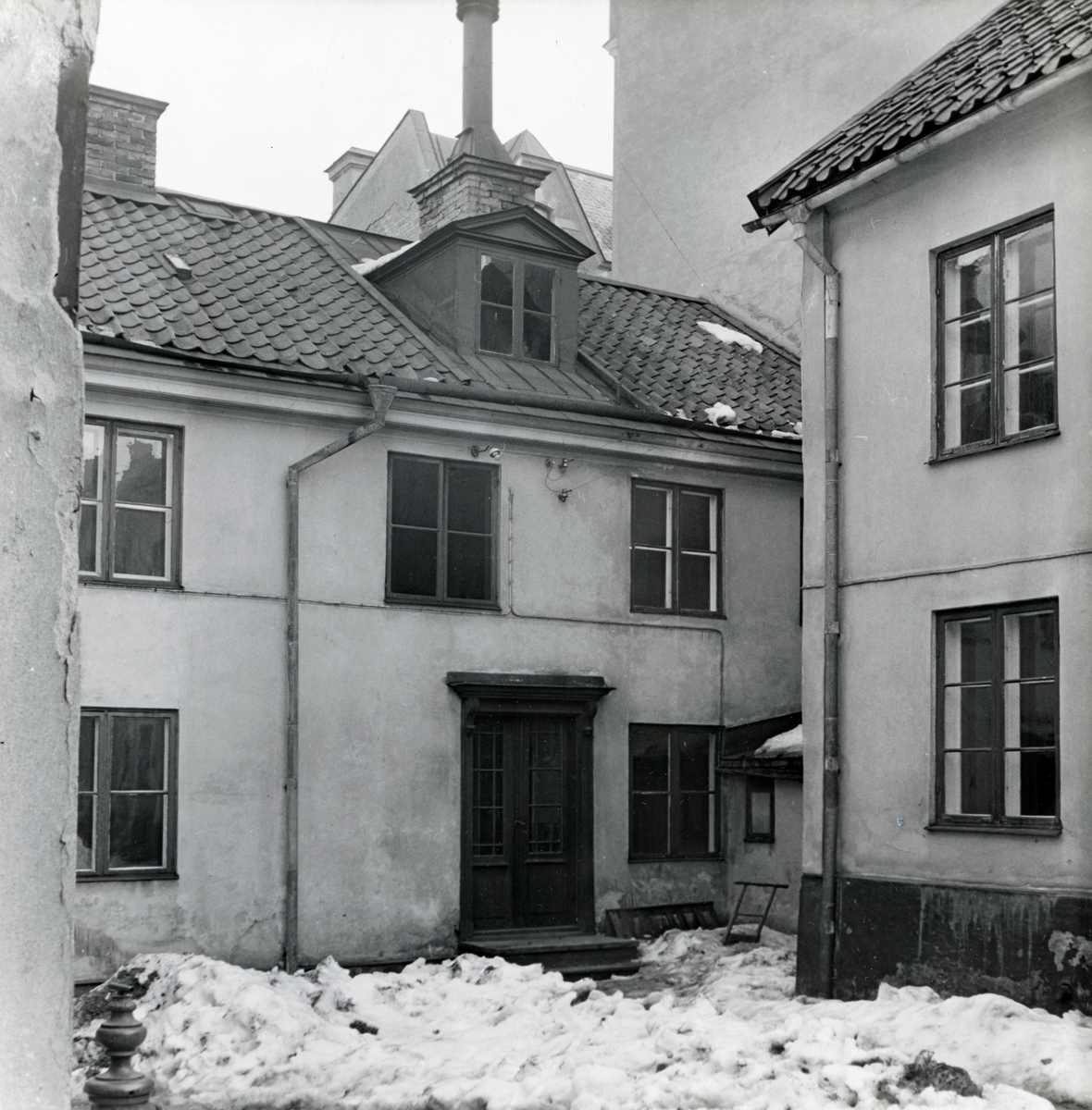 Gårdsfasad till Tunnbindaregatan 19 i kvarteret Haken, Norrköping. Bilden är tagen i samband med rivningsansökan 1953. John Journath Byggnadsbyrå kommer under 1950-talet bygga nya bostäder inom kvarteret med början på tomten Haken nr 9. Vy mot öster.