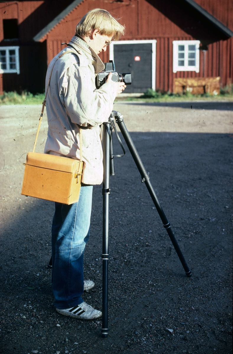 Fotograf Bengt Fredén från Upplandsmuseet fotograferar i samband med samtidsundersökning av Hacksta gård, Enköpings-Näs socken, Uppland 1981 - 1982