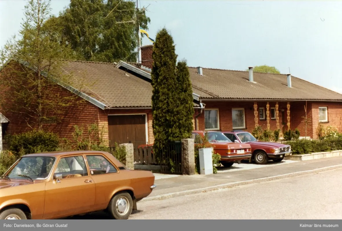 Bostadshus i tegel och sadeltak. Ett par bilar står parkerade vid garaget på Sparregatan. Ägaren hette Björneman och Bertil Danielsson var byggmästare.