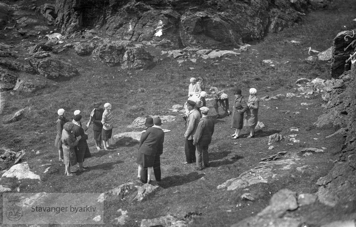 En gruppe mennesker blant fjellknauser.
