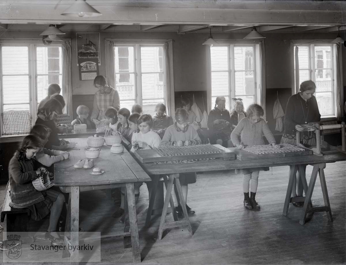 Jenter med flettingsarbeid. Arbeidsstuene ble opprettet i 1919 og holdt først til i Storms skole før de flyttet til St. Svithuns skole.